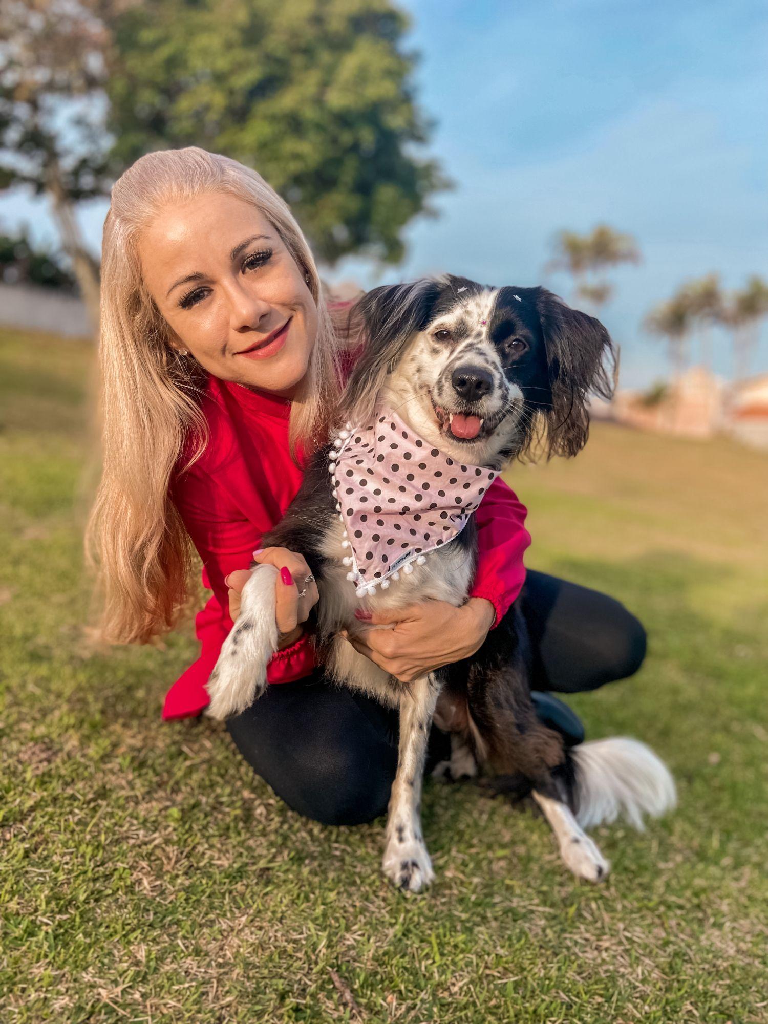 Dra. Loane sorrindo com um cachorro
